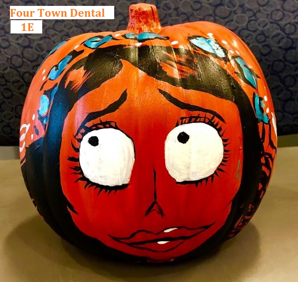 Woman's face painted on a pumpkin